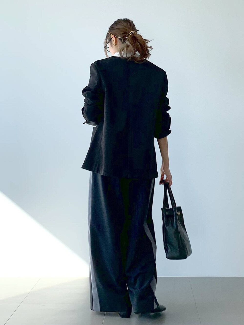 ブラック系のノーカラージャケット、ホワイト系のシャツ/ブラウス、ブラック系のつなぎ/オールインワンを着用したレディースの春コーディネートの5枚目の写真