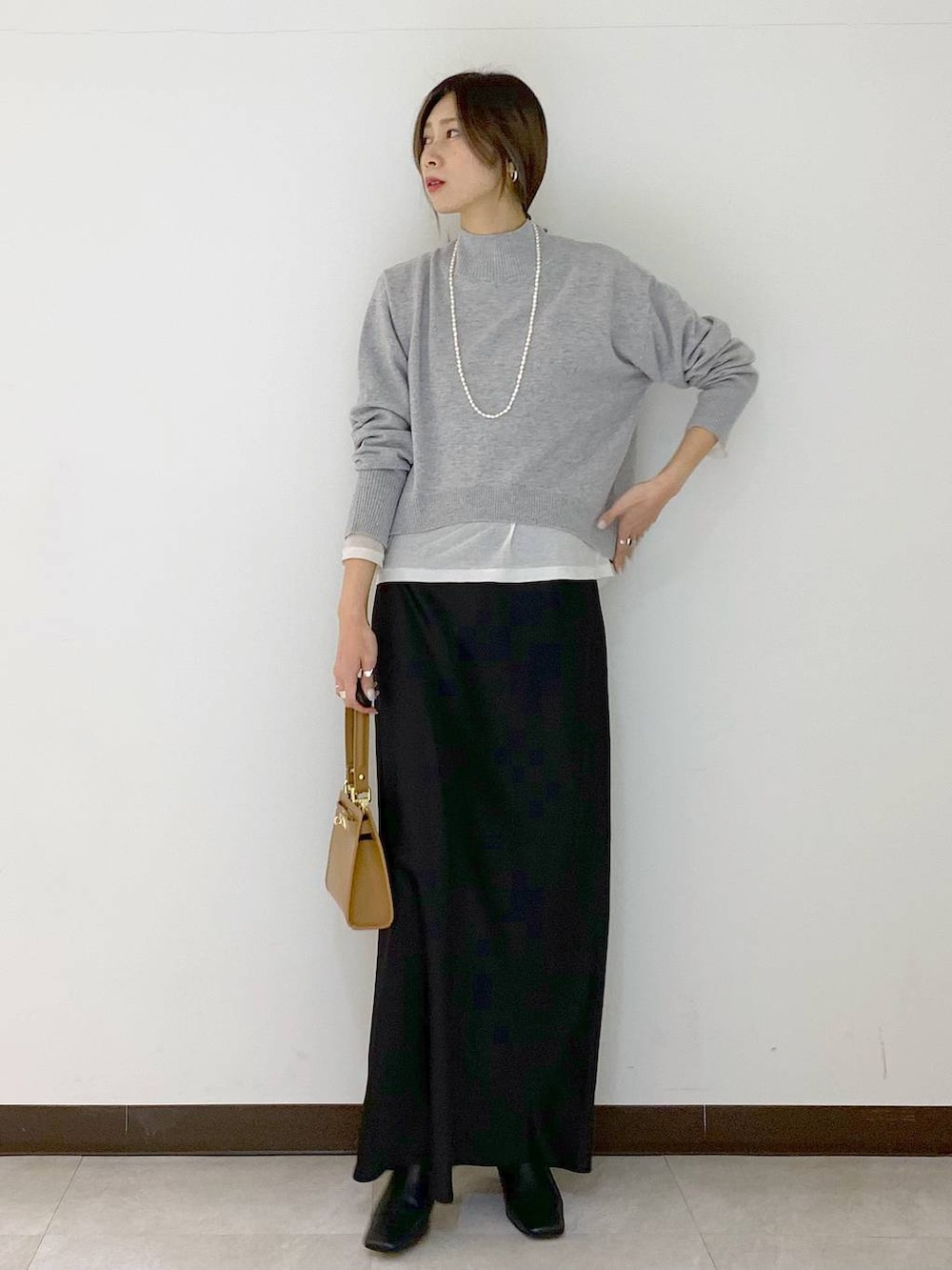 ホワイト系のTシャツ/カットソー、イエロー系のショルダーバッグ、ブラック系のスカートを着用したレディースの冬コーディネートの3枚目の写真