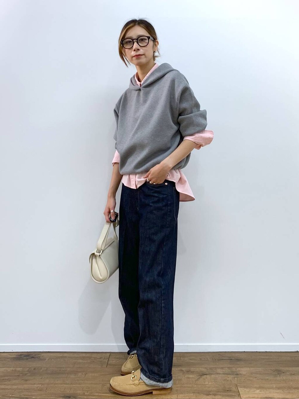 ホワイト系のショルダーバッグ、ピンク系のシャツ/ブラウス、ブルー系のデニムパンツを着用したレディースの秋コーディネートの7枚目の写真