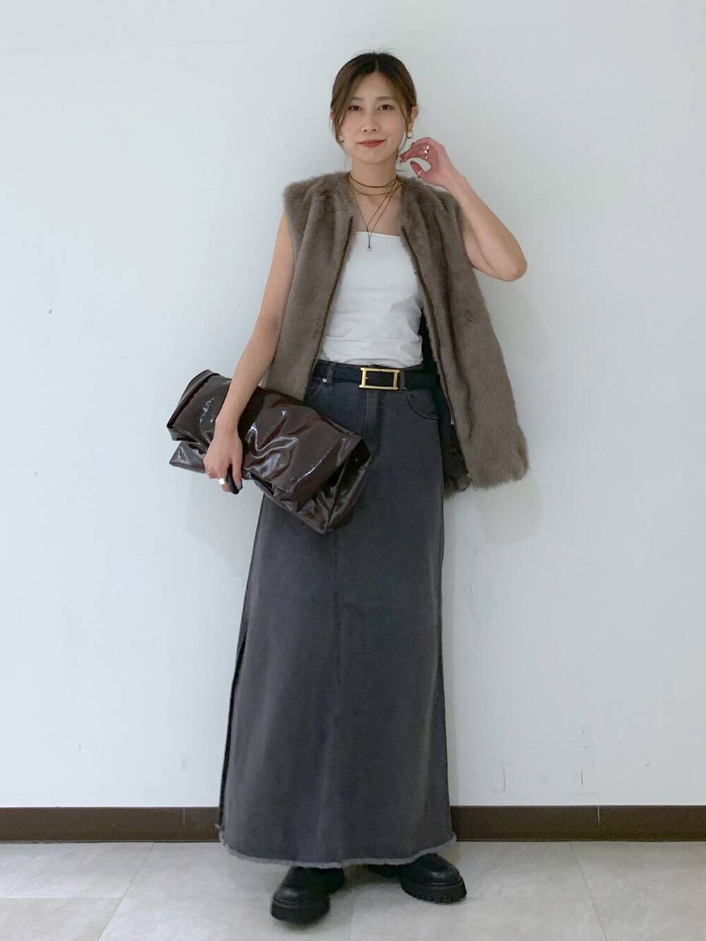 ホワイト系のキャミソール、グレー系のスカート、ブラウン系のその他アウターを着用したレディースの秋コーディネートの2枚目の写真