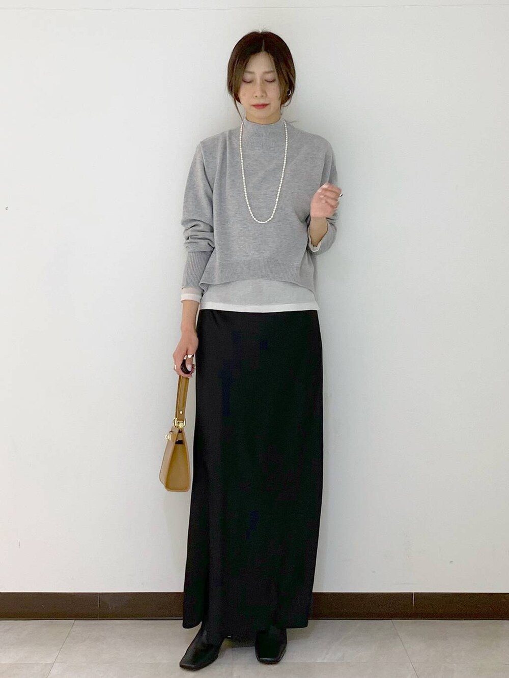 ホワイト系のTシャツ/カットソー、イエロー系のショルダーバッグ、ブラック系のスカートを着用したレディースの冬コーディネートの8枚目の写真