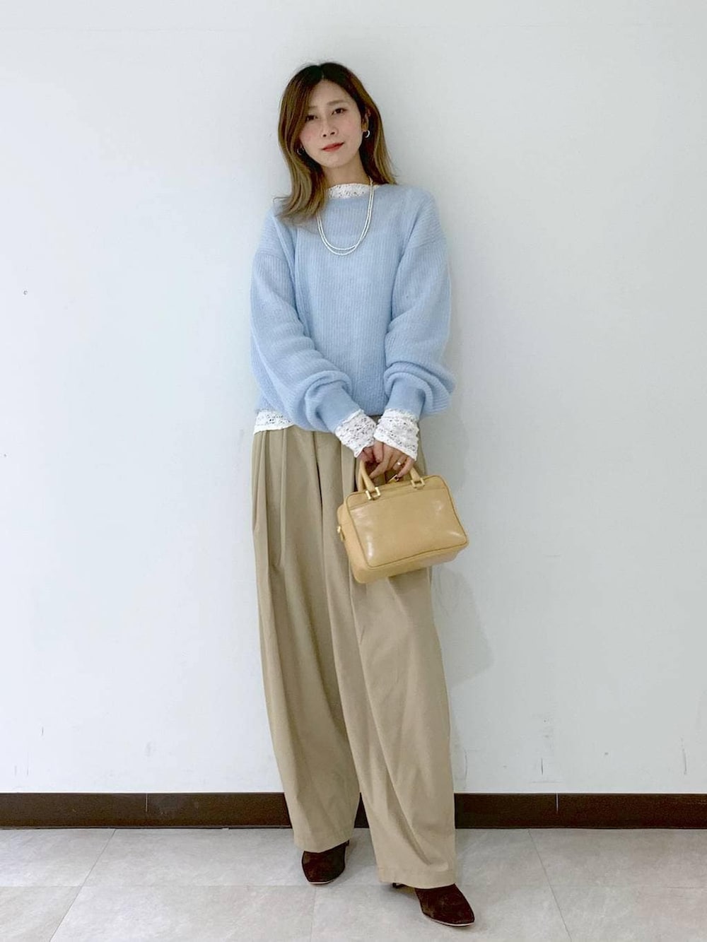 ベージュ系のショルダーバッグ、ベージュ系のその他パンツ、ホワイト系のTシャツ/カットソーを着用したレディースの冬コーディネートの6枚目の写真