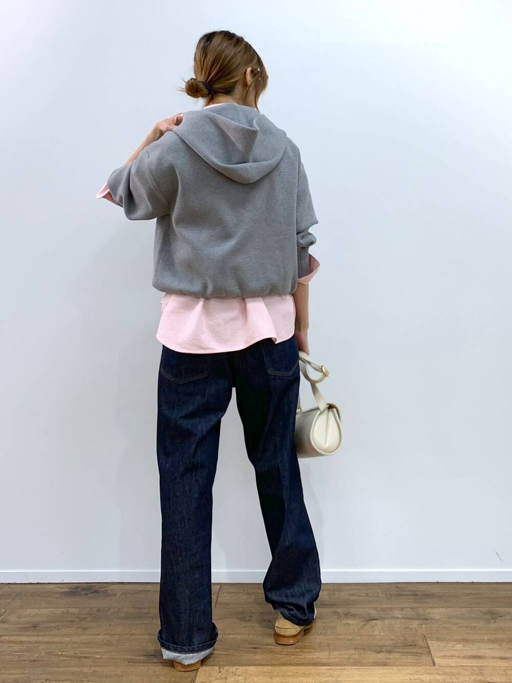 ホワイト系のショルダーバッグ、ピンク系のシャツ/ブラウス、ブルー系のデニムパンツを着用したレディースの秋コーディネートの4枚目の写真