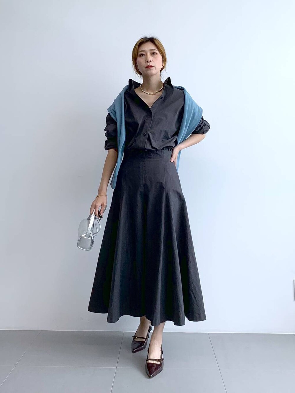 ブルー系のTシャツ/カットソー、シルバー系のショルダーバッグ、グレー系のスカートを着用したレディースの秋コーディネートの5枚目の写真