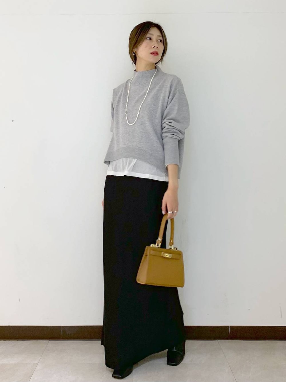 ホワイト系のTシャツ/カットソー、イエロー系のショルダーバッグ、ブラック系のスカートを着用したレディースの冬コーディネートの4枚目の写真