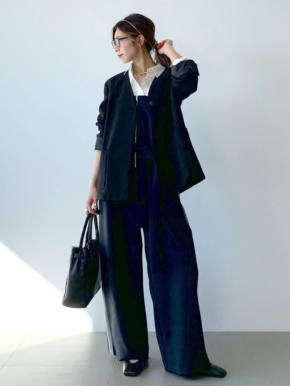 ブラック系のノーカラージャケット、ホワイト系のシャツ/ブラウス、ブラック系のつなぎ/オールインワンを着用したレディースの春コーディネートの3枚目の写真