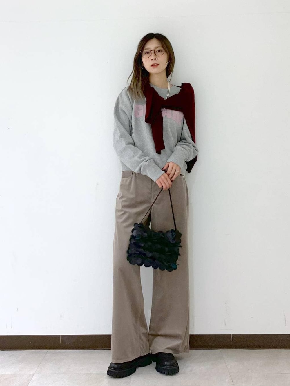 レッド系のカーディガン/ボレロ、ブラック系のショルダーバッグ、ブラック系のサンダルを着用したレディースの冬コーディネートの6枚目の写真