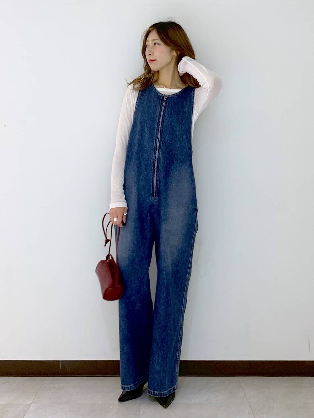 レッド系のショルダーバッグ、ホワイト系のTシャツ/カットソー、ブラウン系のソックス/靴下を着用したレディースの秋コーディネートの6枚目の写真