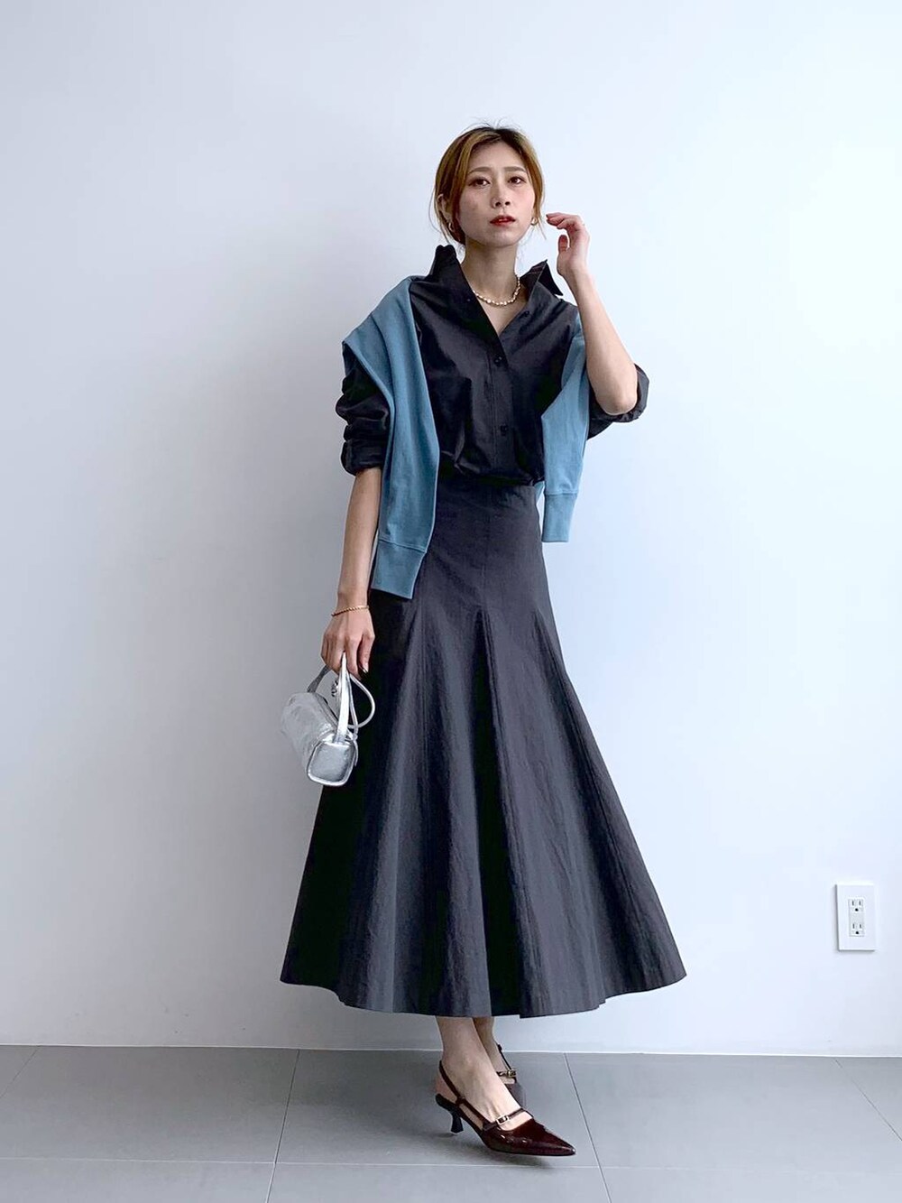 ブルー系のTシャツ/カットソー、シルバー系のショルダーバッグ、グレー系のスカートを着用したレディースの秋コーディネートの8枚目の写真