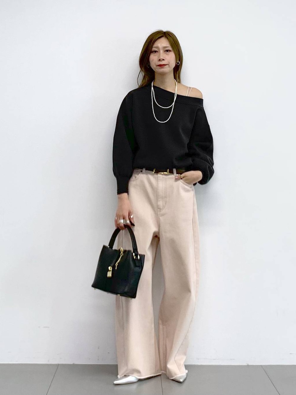 ピンク系のデニムパンツ、シルバー系のパンプス、グレー系のニット/セーターを着用したレディースの冬コーディネートの5枚目の写真