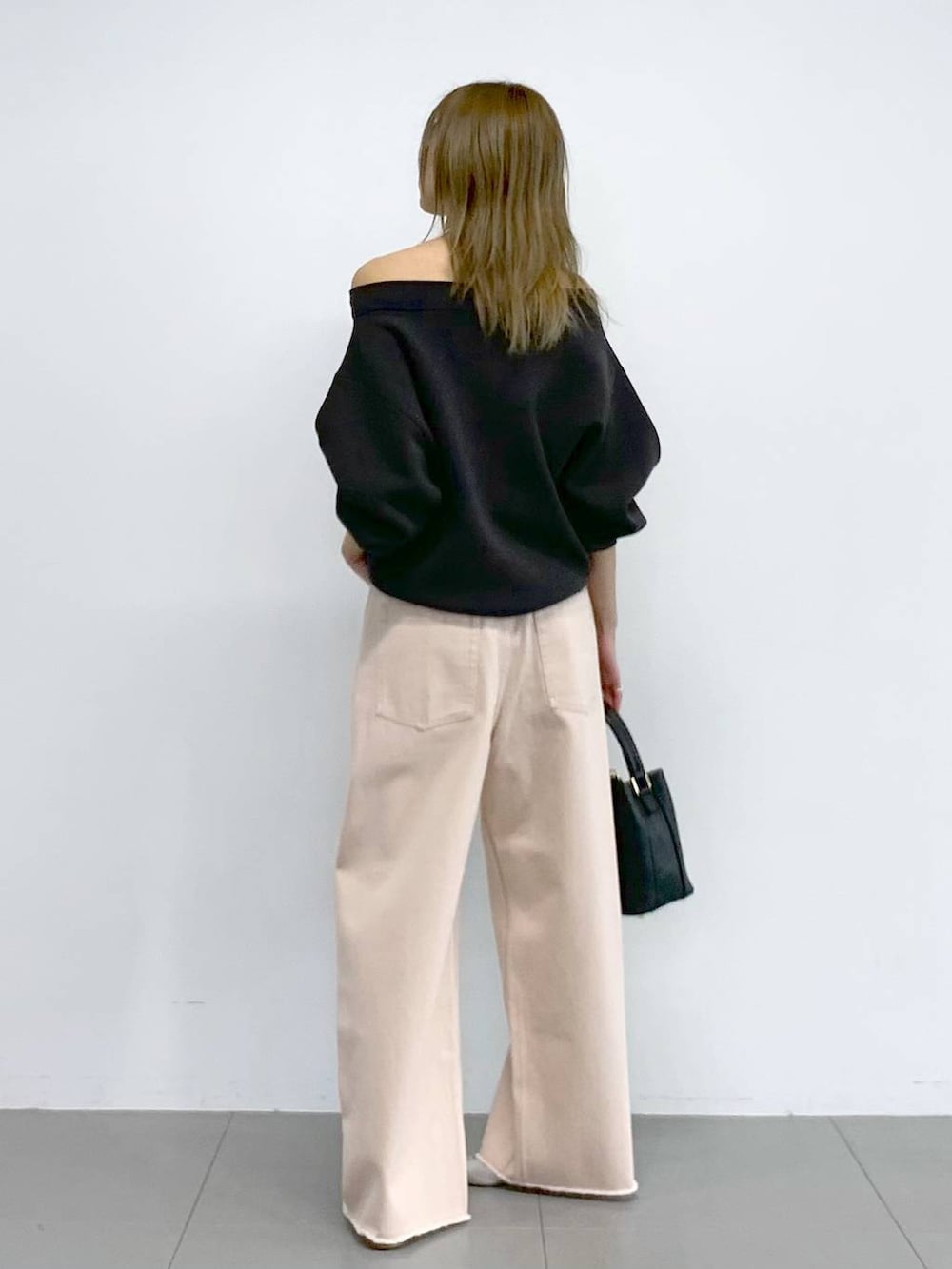 ピンク系のデニムパンツ、シルバー系のパンプス、グレー系のニット/セーターを着用したレディースの冬コーディネートの3枚目の写真