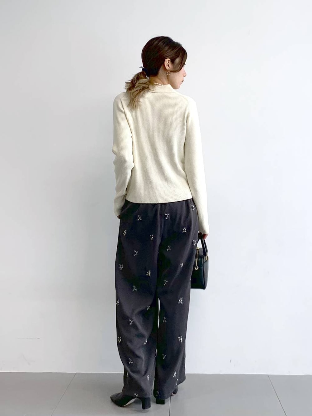 ブラック系のブーツ、ブラック系のボストンバッグ、グレー系のその他パンツを着用したレディースの冬コーディネートの4枚目の写真