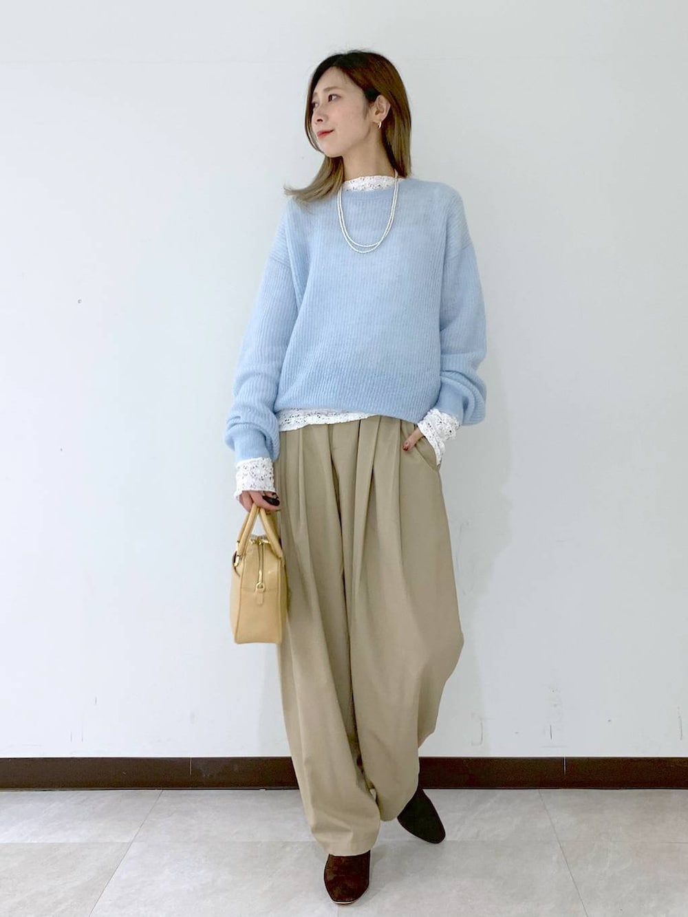 ベージュ系のショルダーバッグ、ベージュ系のその他パンツ、ホワイト系のTシャツ/カットソーを着用したレディースの冬コーディネートの2枚目の写真