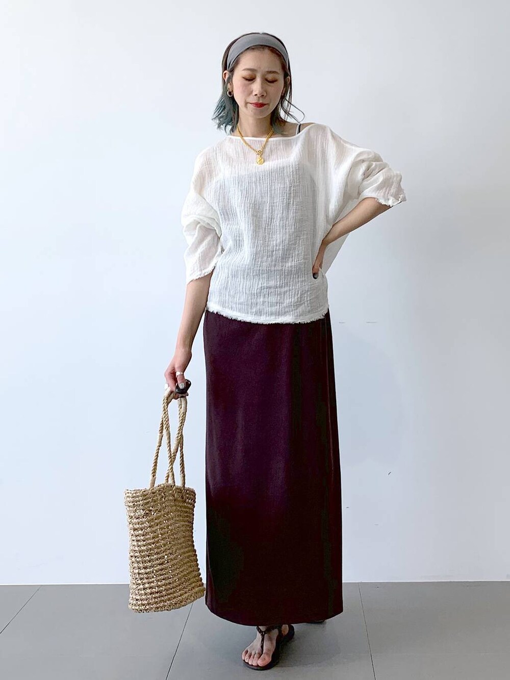 ベージュ系のかごバッグ、ブラウン系のサンダル、ブラウン系のワンピースを着用したレディースの夏コーディネートの2枚目の写真