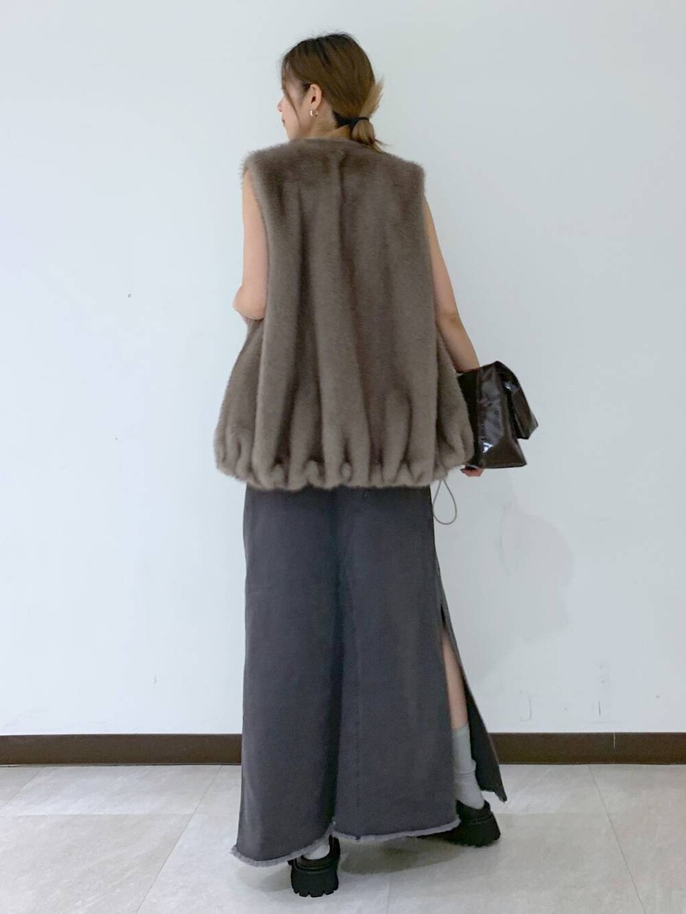 ホワイト系のキャミソール、グレー系のスカート、ブラウン系のその他アウターを着用したレディースの秋コーディネートの4枚目の写真