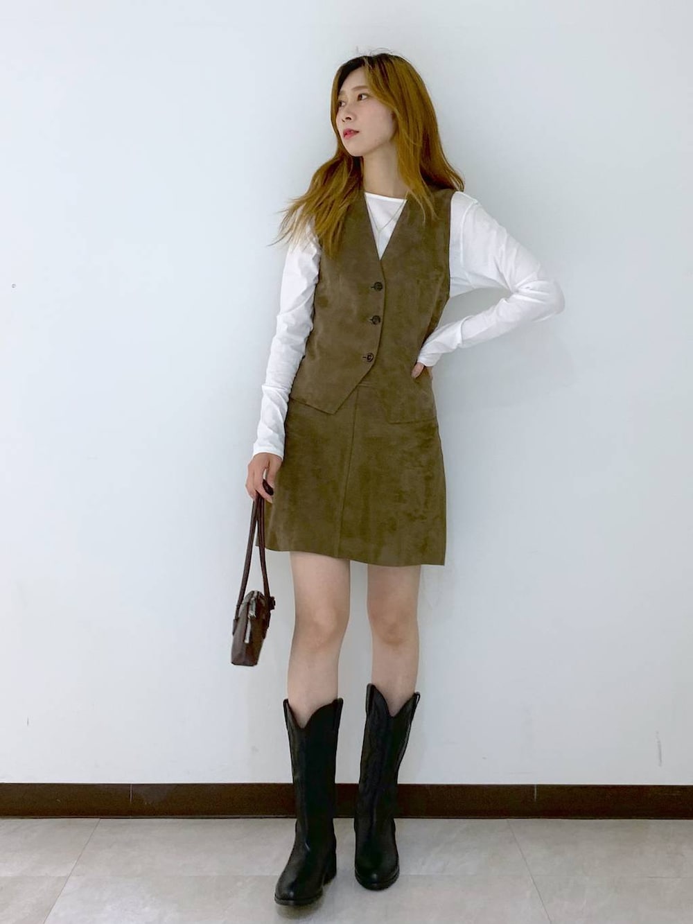 ホワイト系のTシャツ/カットソー、ブラウン系のショルダーバッグ、ベージュ系のベストを着用したレディースの秋コーディネートの2枚目の写真