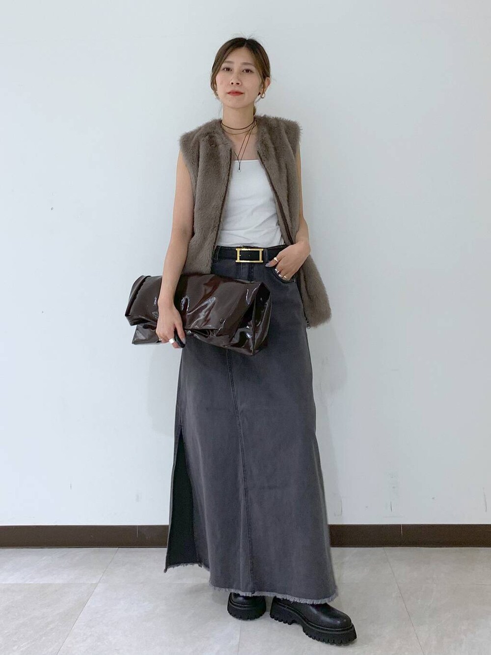 ホワイト系のキャミソール、グレー系のスカート、ブラウン系のその他アウターを着用したレディースの秋コーディネートの7枚目の写真