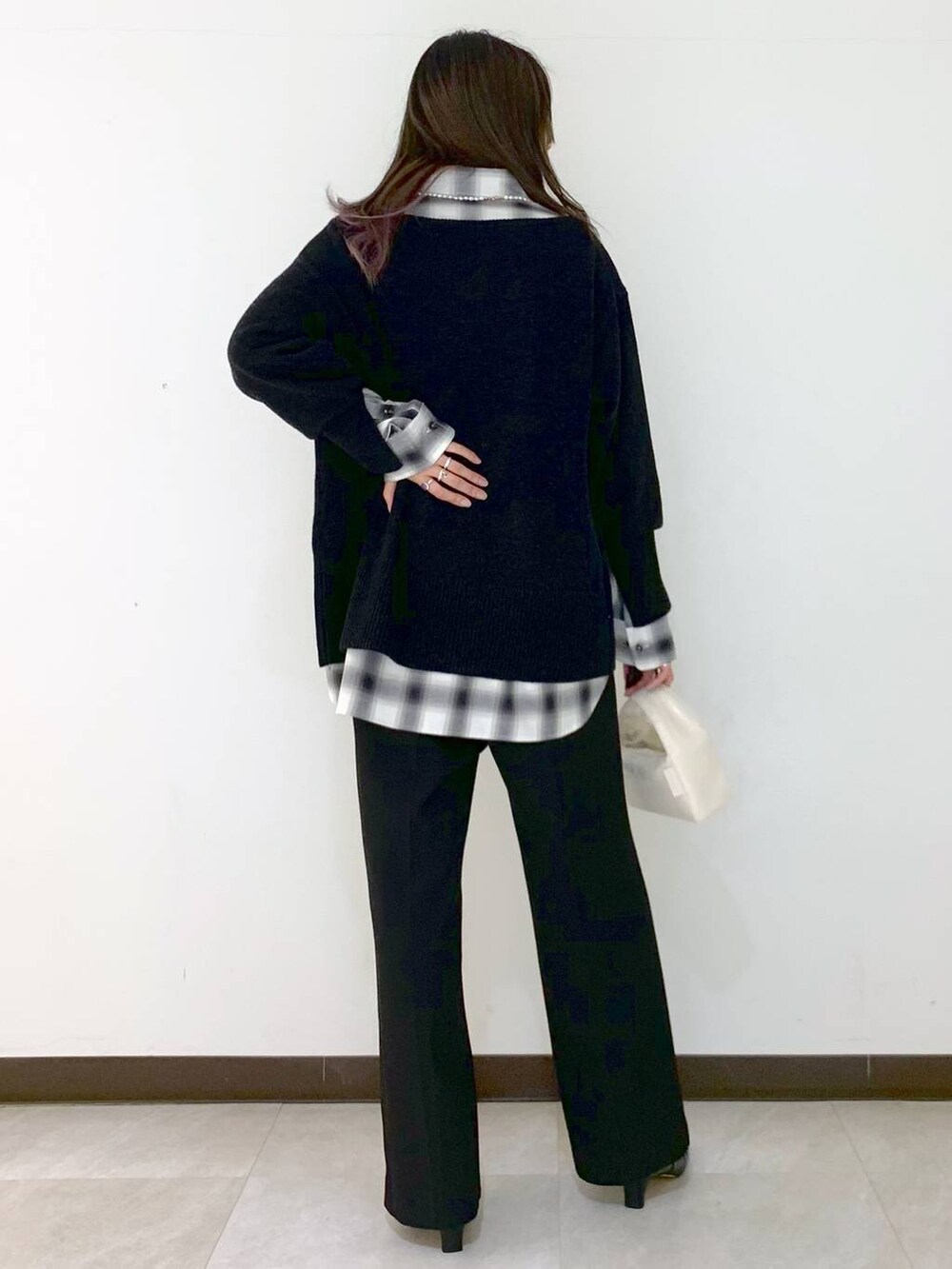 ホワイト系のハンドバッグ、グレー系のニット/セーター、ブラック系のシャツ/ブラウスを着用したレディースの冬コーディネートの5枚目の写真