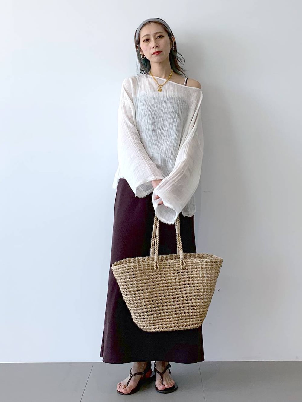 ベージュ系のかごバッグ、ブラウン系のサンダル、ブラウン系のワンピースを着用したレディースの夏コーディネートの6枚目の写真