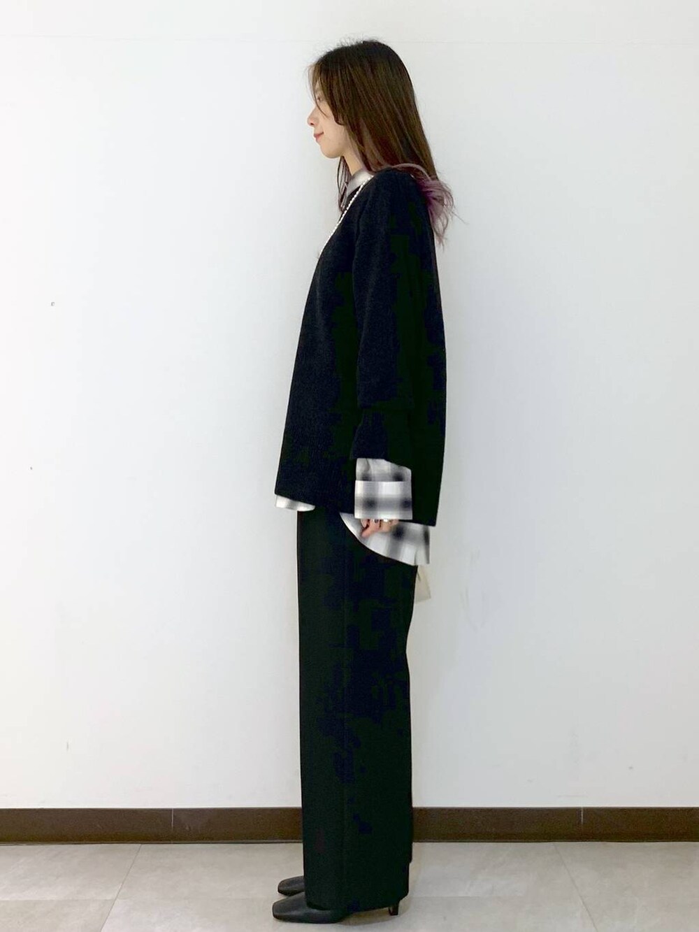 ホワイト系のハンドバッグ、グレー系のニット/セーター、ブラック系のシャツ/ブラウスを着用したレディースの冬コーディネートの4枚目の写真