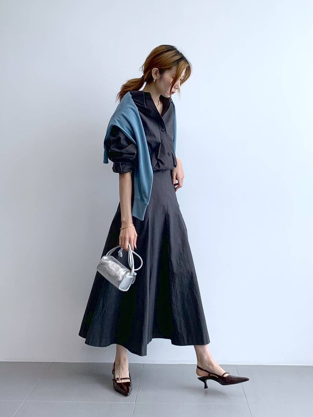 ブルー系のTシャツ/カットソー、シルバー系のショルダーバッグ、グレー系のスカートを着用したレディースの秋コーディネートの3枚目の写真