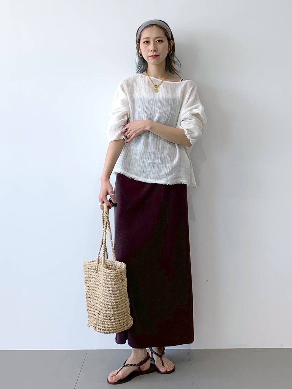 ベージュ系のかごバッグ、ブラウン系のサンダル、ブラウン系のワンピースを着用したレディースの夏コーディネートの3枚目の写真