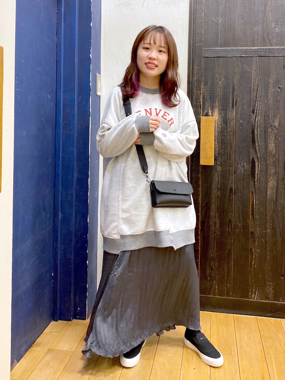 グレー系のスウェット、グレー系のスカート、ブラック系のスニーカーを着用したレディースの冬コーディネートの2枚目の写真