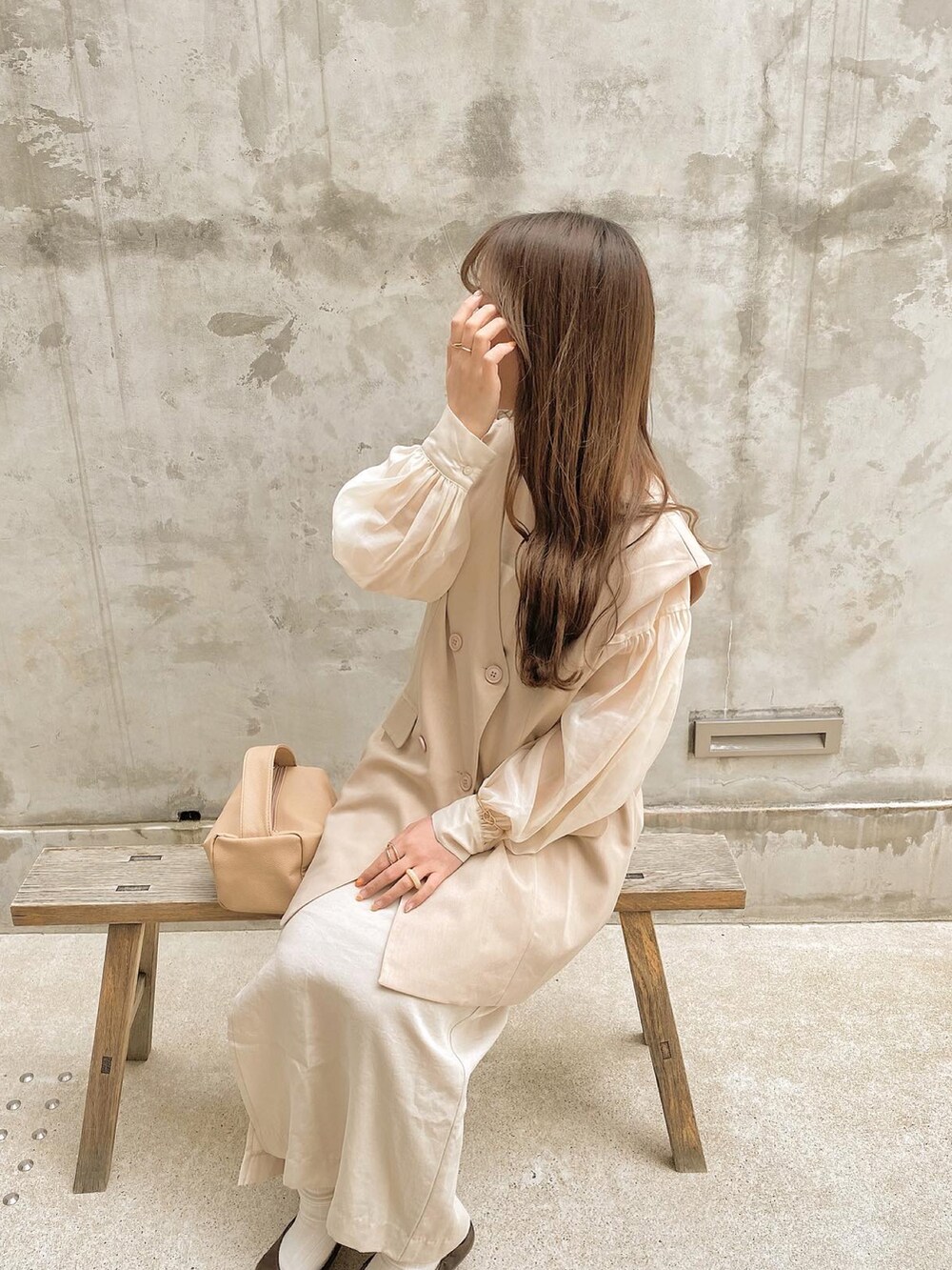 ベージュ系のスカート、ベージュ系のベスト、ベージュ系のバッグを着用したレディースの春コーディネートの2枚目の写真