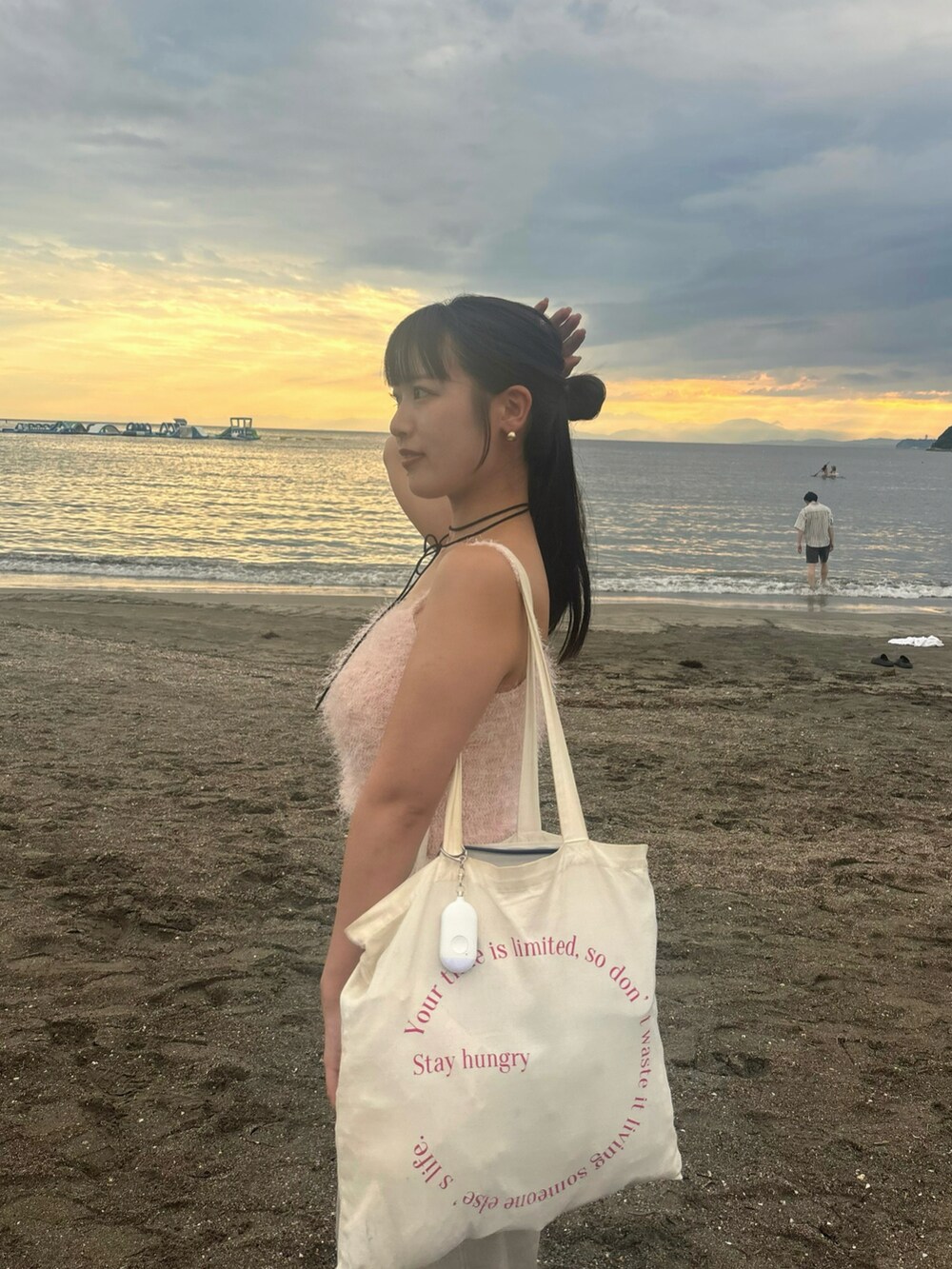 ピンク系のニット/セーターを着用したレディースの夏コーディネートの2枚目の写真