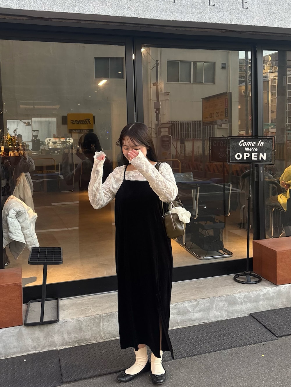 ブラック系のワンピース、ベージュ系のTシャツ/カットソーを着用したレディースの春コーディネートの3枚目の写真