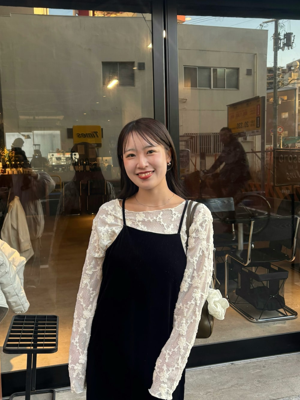 ブラック系のワンピース、ベージュ系のTシャツ/カットソーを着用したレディースの春コーディネートの2枚目の写真