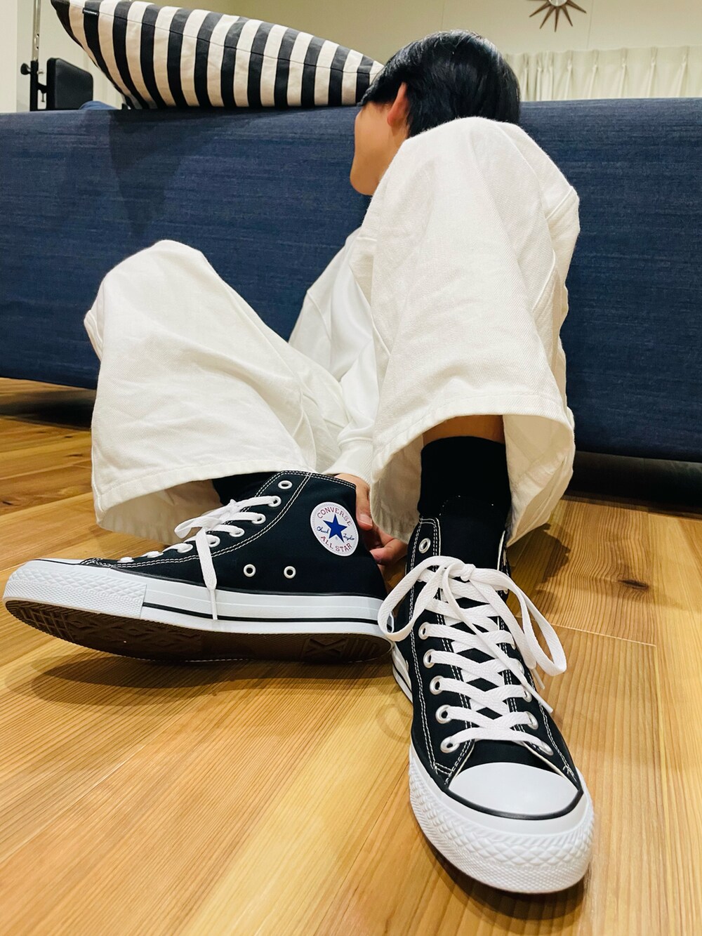 ホワイト系のデニムパンツ、ブラック系のスニーカーを着用したレディースの春コーディネートの2枚目の写真