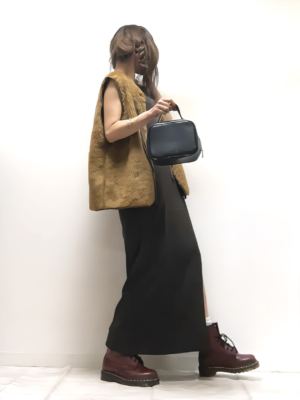 ブラウン系のベスト、ブラウン系のワンピース、ブラック系のボストンバッグを着用したレディースの夏コーディネートの2枚目の写真