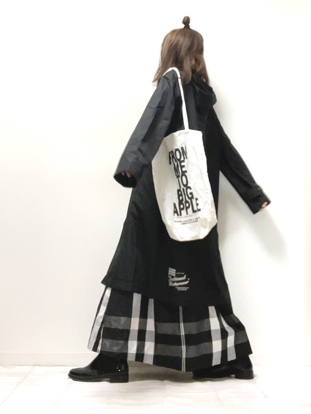 ブラック系のスカート、ブラック系のレインシューズ、ブラック系のトートバッグを着用したレディースの春コーディネートの2枚目の写真