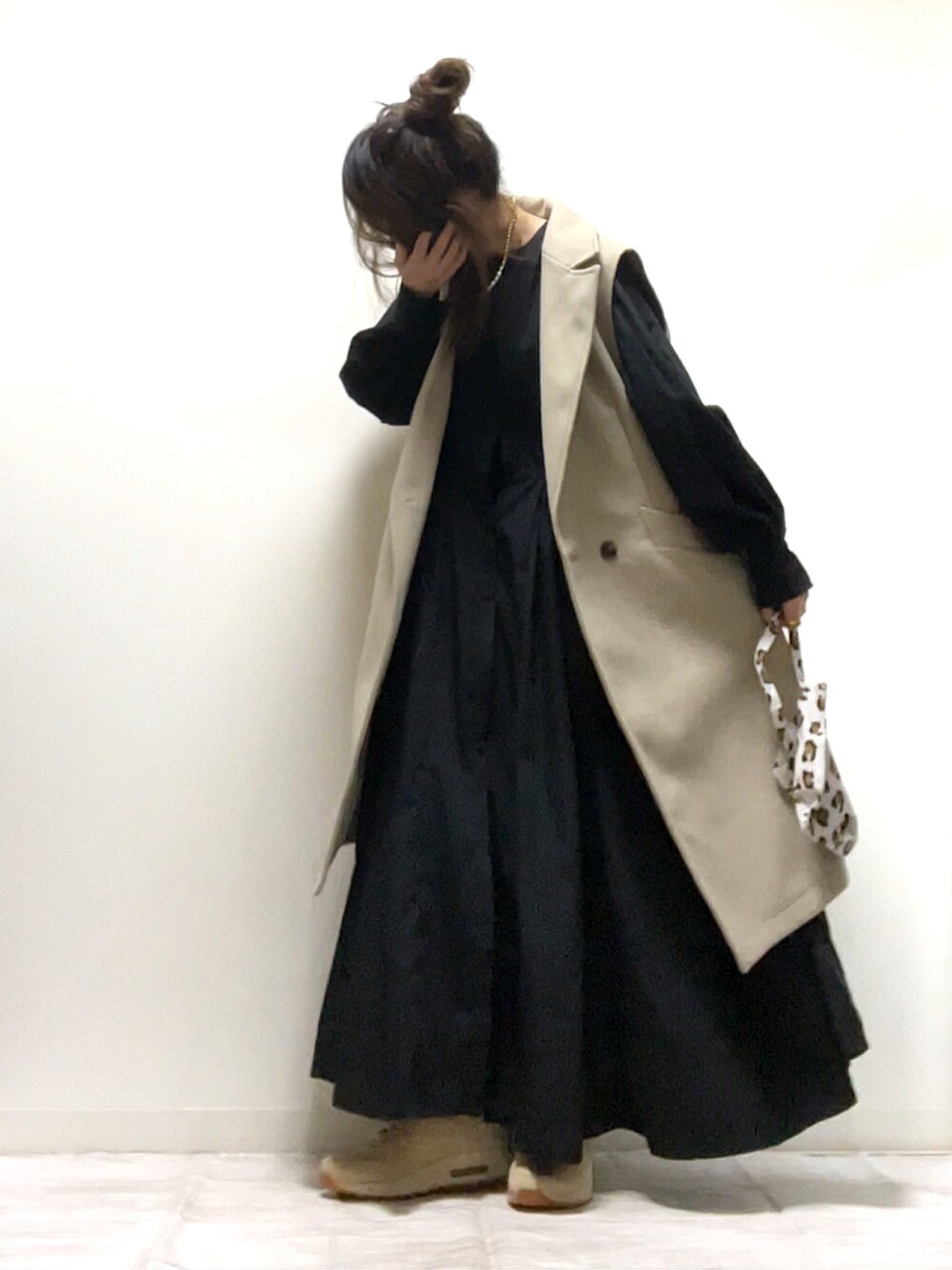 ブラック系のシャツワンピース、ベージュ系のベスト、ベージュ系のスニーカーを着用したレディースの秋コーディネートの3枚目の写真