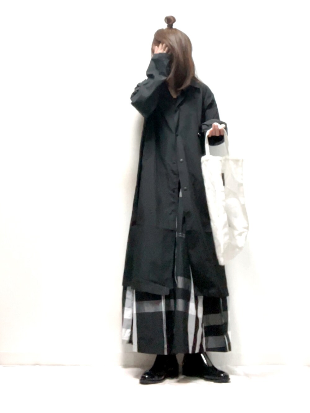 ブラック系のスカート、ブラック系のレインシューズ、ブラック系のトートバッグを着用したレディースの春コーディネートの3枚目の写真