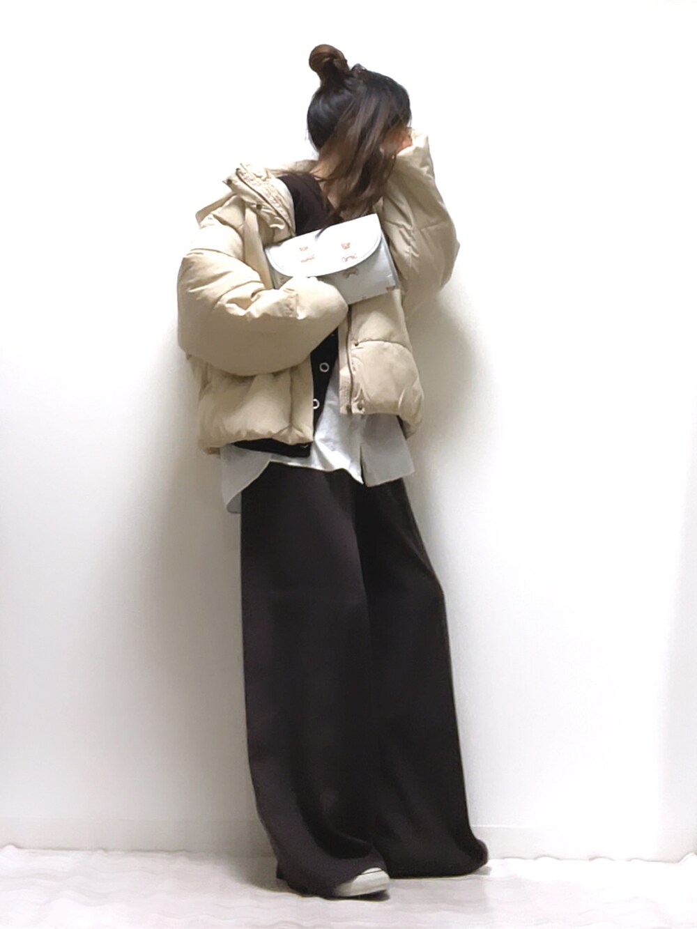 ホワイト系のダウンジャケット/コート、ブラウン系のカーディガン/ボレロ、ブラウン系のその他パンツを着用したレディースの冬コーディネートの4枚目の写真