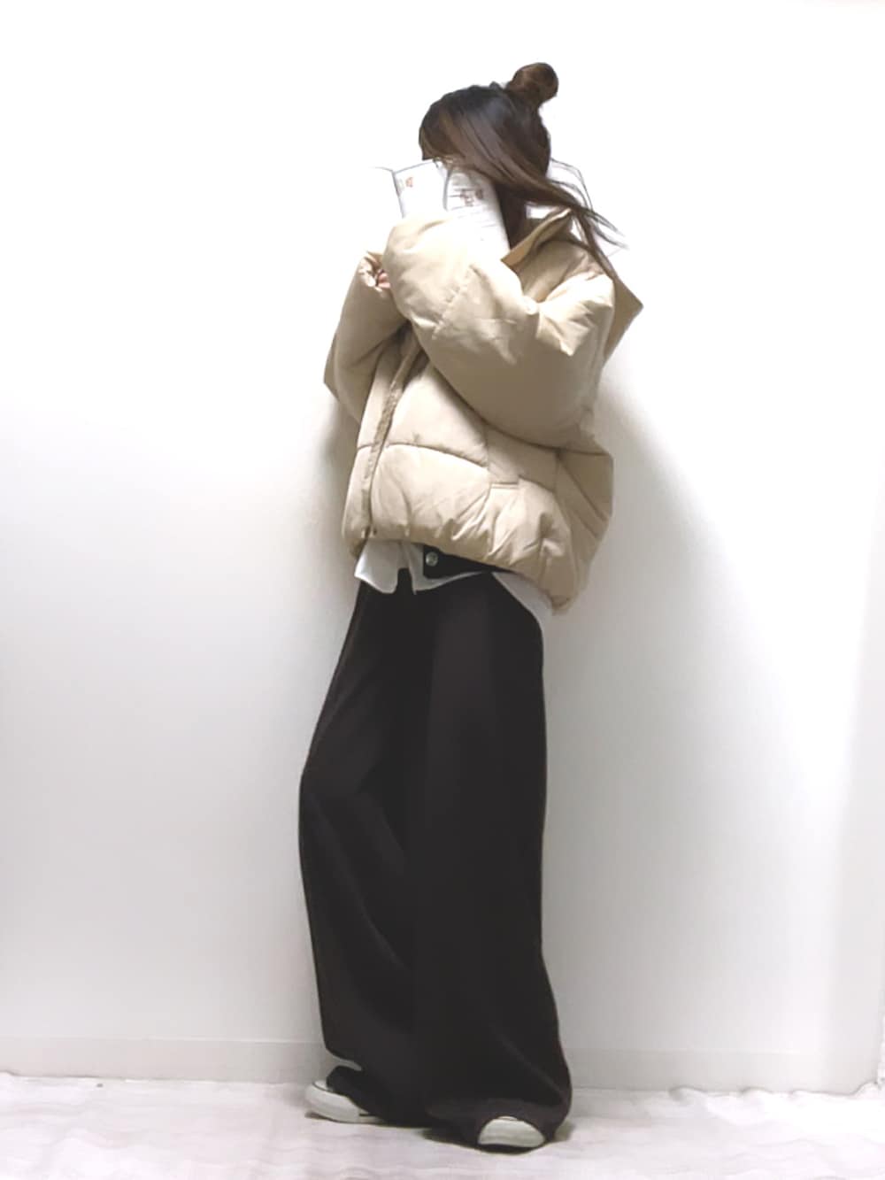 ホワイト系のダウンジャケット/コート、ブラウン系のカーディガン/ボレロ、ブラウン系のその他パンツを着用したレディースの冬コーディネートの2枚目の写真