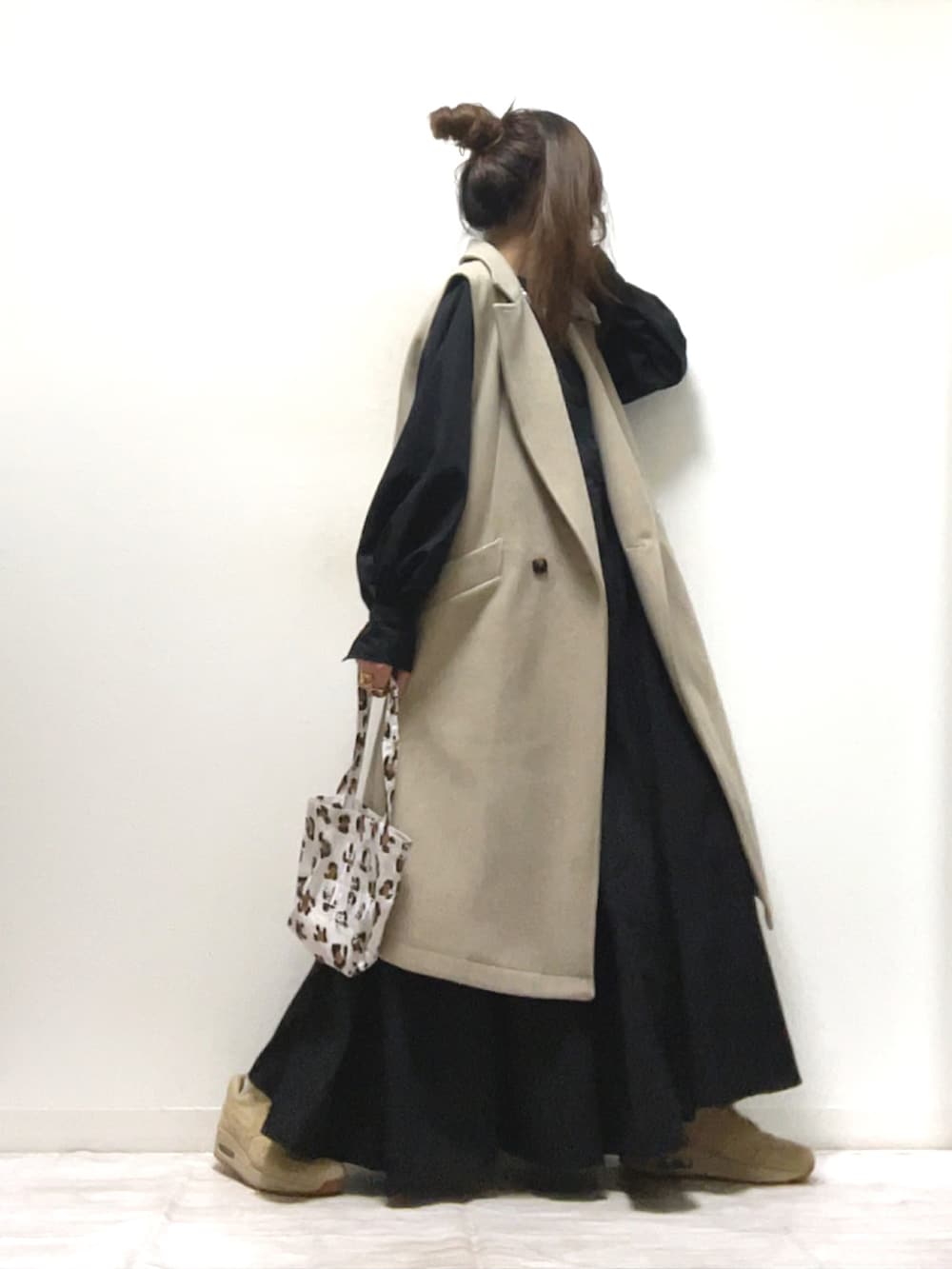 ブラック系のシャツワンピース、ベージュ系のベスト、ベージュ系のスニーカーを着用したレディースの秋コーディネートの2枚目の写真