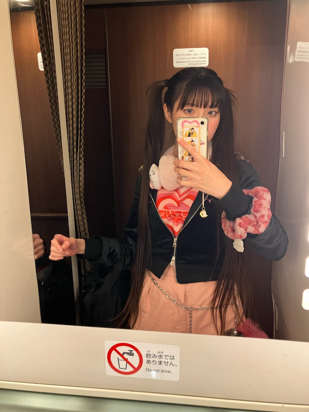 ブラック系のパーカー、ピンク系のスリッポン、ピンク系のTシャツ/カットソーを着用したレディースの冬コーディネートの3枚目の写真