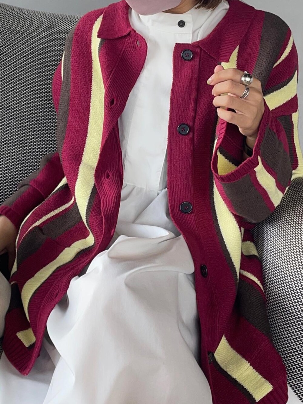 ブラック系のブーツ、ホワイト系のワンピース、ピンク系のカーディガン/ボレロを着用したレディースの秋コーディネートの2枚目の写真