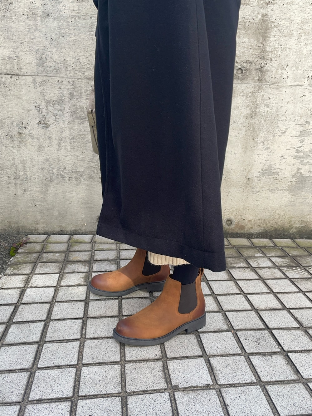 ベージュ系のショルダーバッグ、ブラック系のダッフルコート、ブラウン系のブーツを着用したレディースの秋コーディネートの4枚目の写真