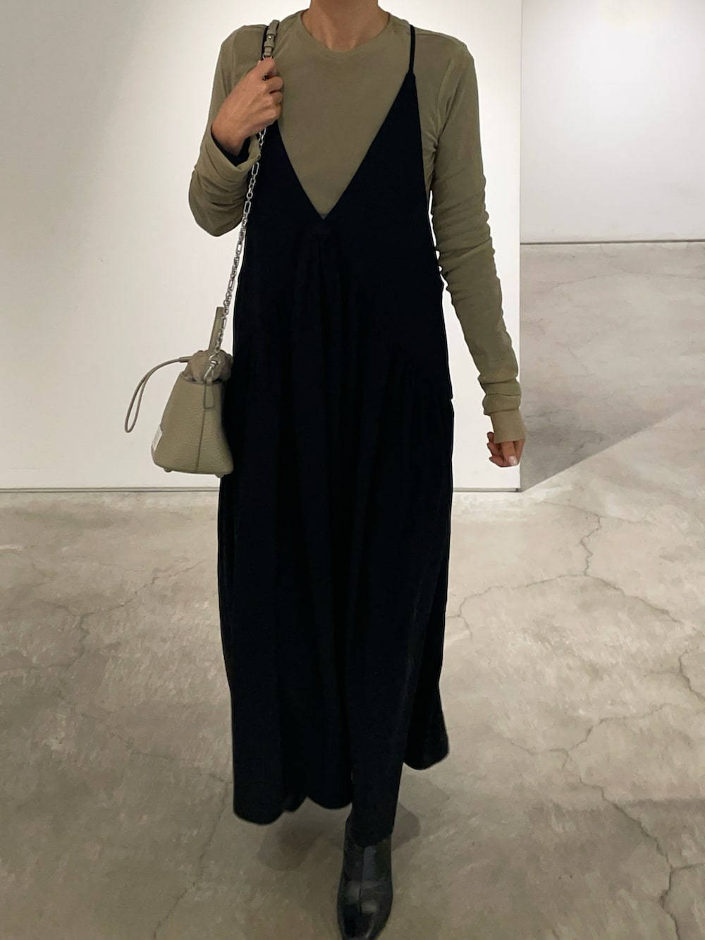 ベージュ系のショルダーバッグ、ブラック系のワンピース、ベージュ系のTシャツ/カットソーを着用したレディースの冬コーディネートの3枚目の写真