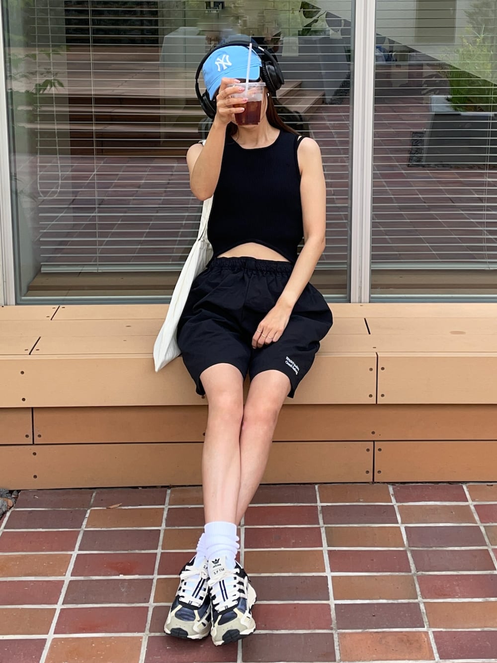 ブラック系のその他パンツ、ホワイト系のトートバッグ、ブルー系のキャップを着用したレディースの夏コーディネートの2枚目の写真