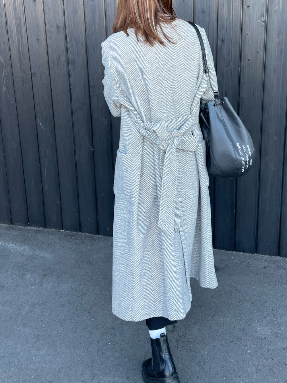 ブラック系のバッグ、ブラック系のブーツ、グレー系のその他アウターを着用したレディースの秋コーディネートの2枚目の写真