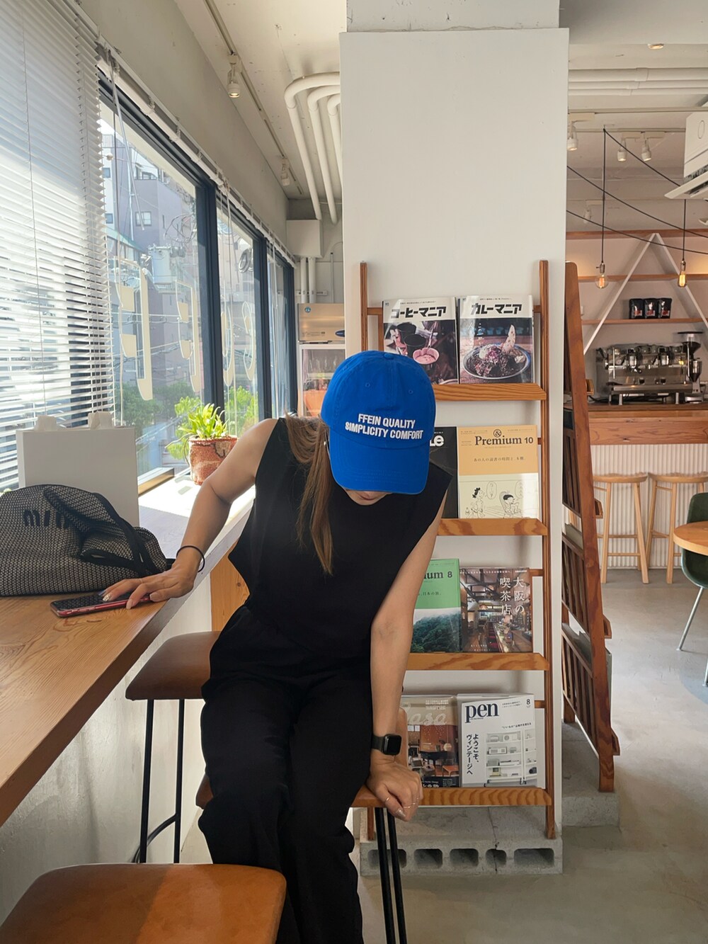 ブラック系のTシャツ/カットソー、ブルー系のキャップを着用したレディースの秋コーディネートの3枚目の写真