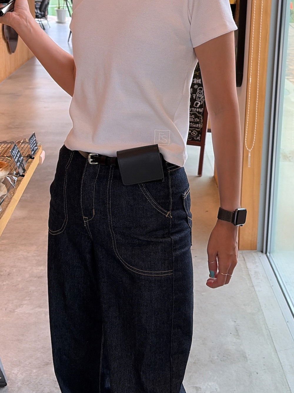 ブルー系のデニムパンツ、ホワイト系のTシャツ/カットソー、ブラック系のベルトを着用したレディースの夏コーディネートの2枚目の写真