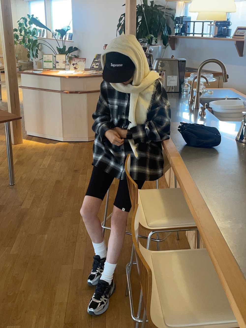 ブラック系のシャツ/ブラウス、ホワイト系のバンダナ/スカーフ、ブラック系のキャップを着用したレディースの秋コーディネートの2枚目の写真