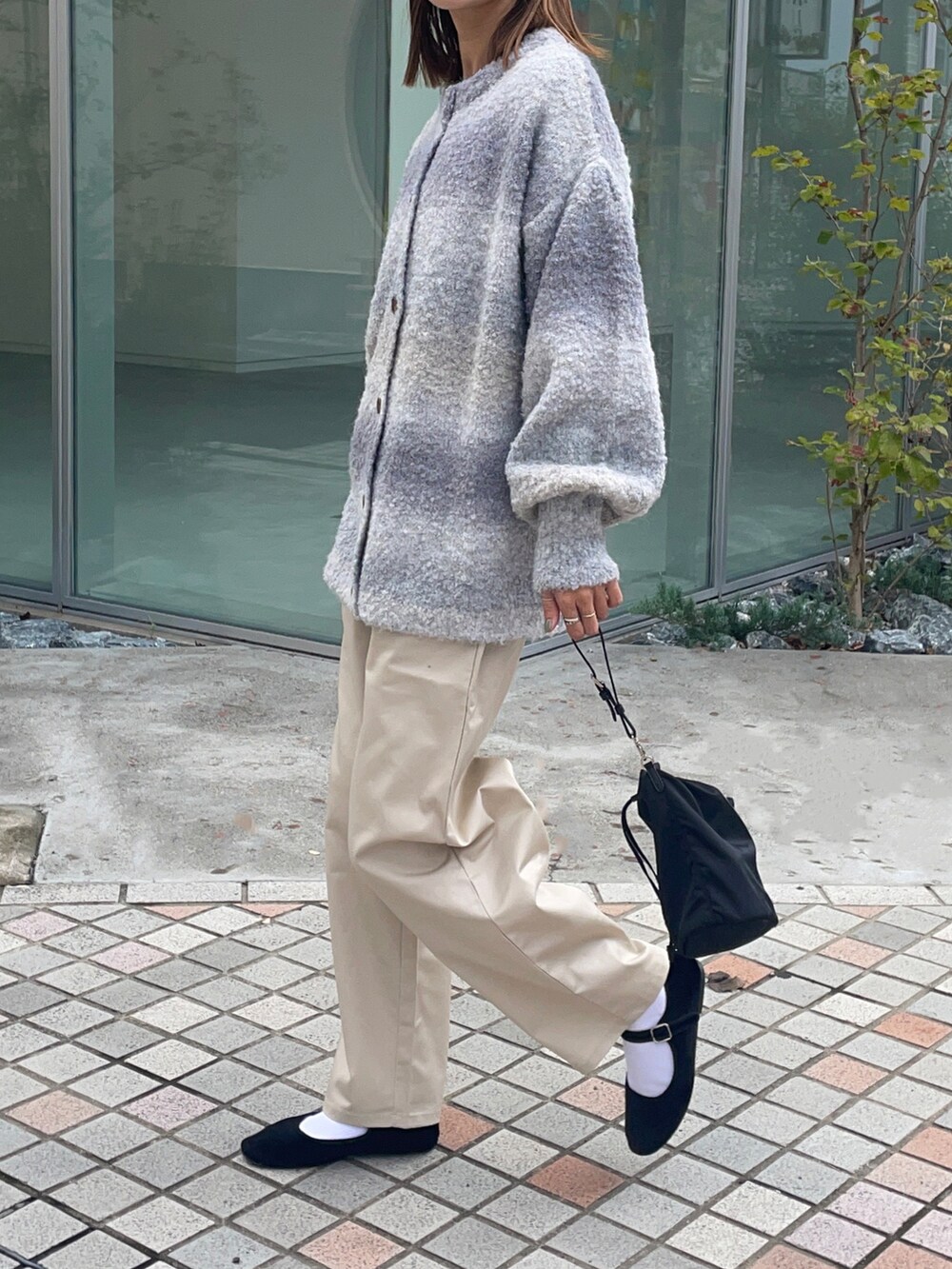 ブラック系のショルダーバッグ、ベージュ系のチノパンツ、パープル系のカーディガン/ボレロを着用したレディースの秋コーディネートの2枚目の写真