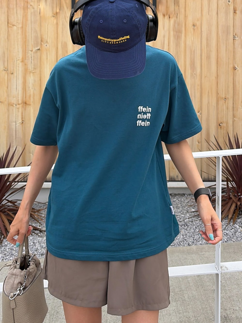 グリーン系のTシャツ/カットソー、ベージュ系のショルダーバッグ、ブルー系のキャップを着用したレディースの夏コーディネートの2枚目の写真